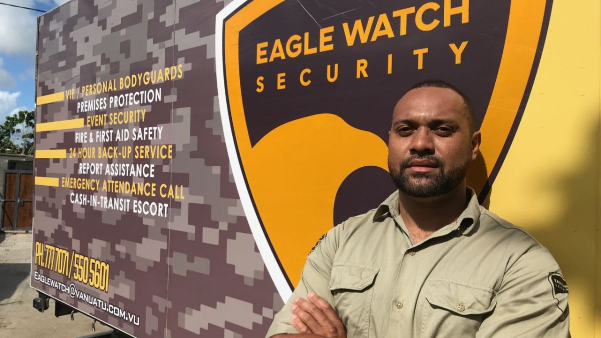 A security man is in front of the truck with company advertising