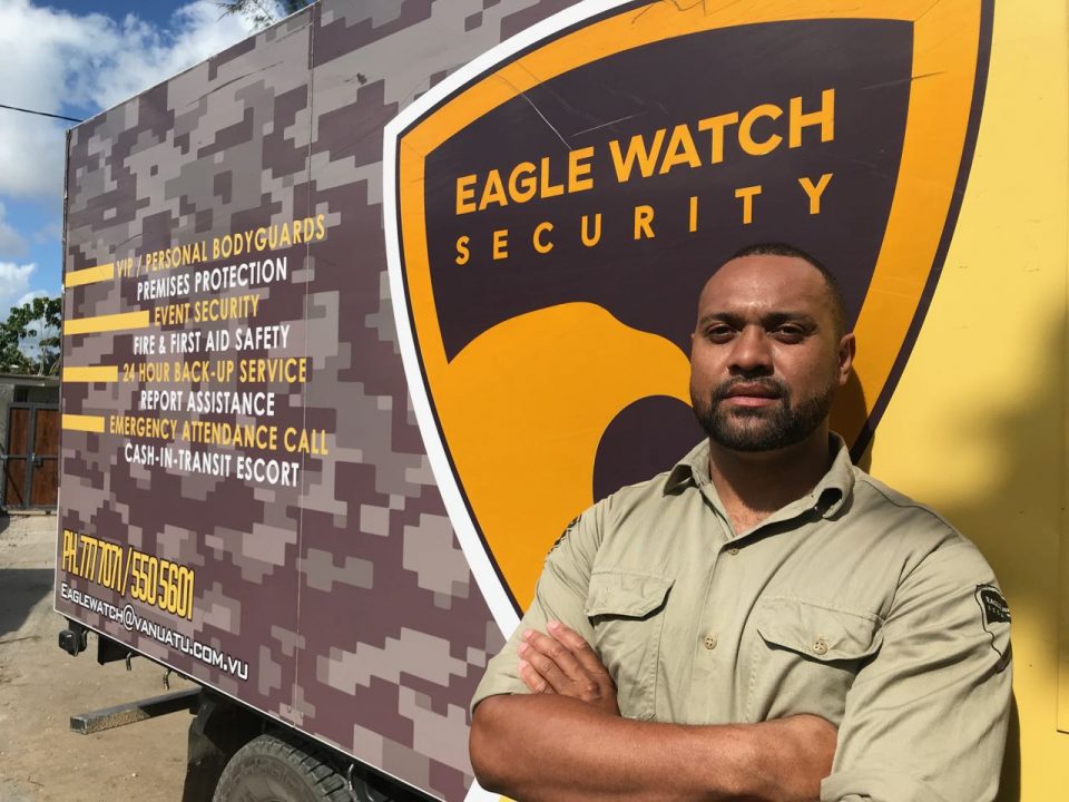 A security man is in front of the truck with company advertising