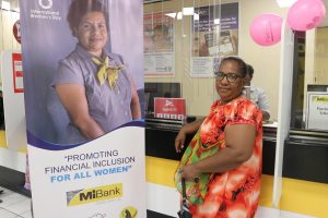 Woman standing next to MiBank Banner